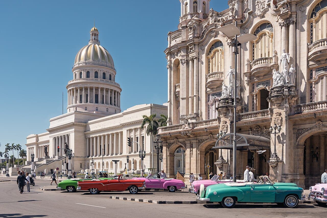 El Capitolio, the National Capitol of Cuba, is a neoclassical public building on the Paseo del Prado in central Havana. Brightly coloured classic American cars line the street in front of the Gran Teatro de La Habana. Ph